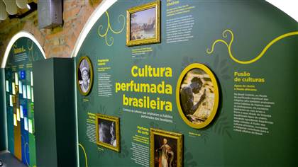 Foto de painel que explica as origens da cultura perfumada brasileira.